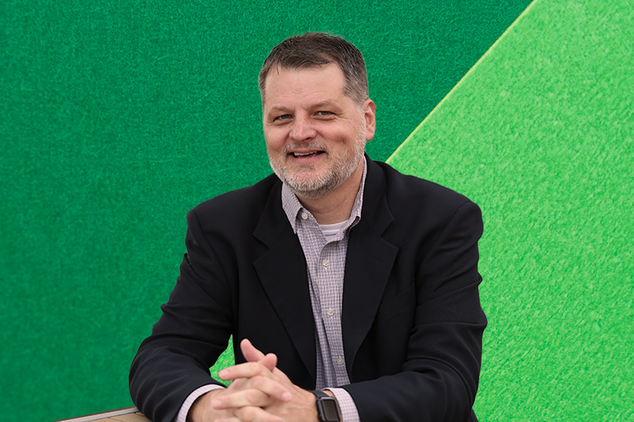 Headshot of Erik Carter on green Connections background